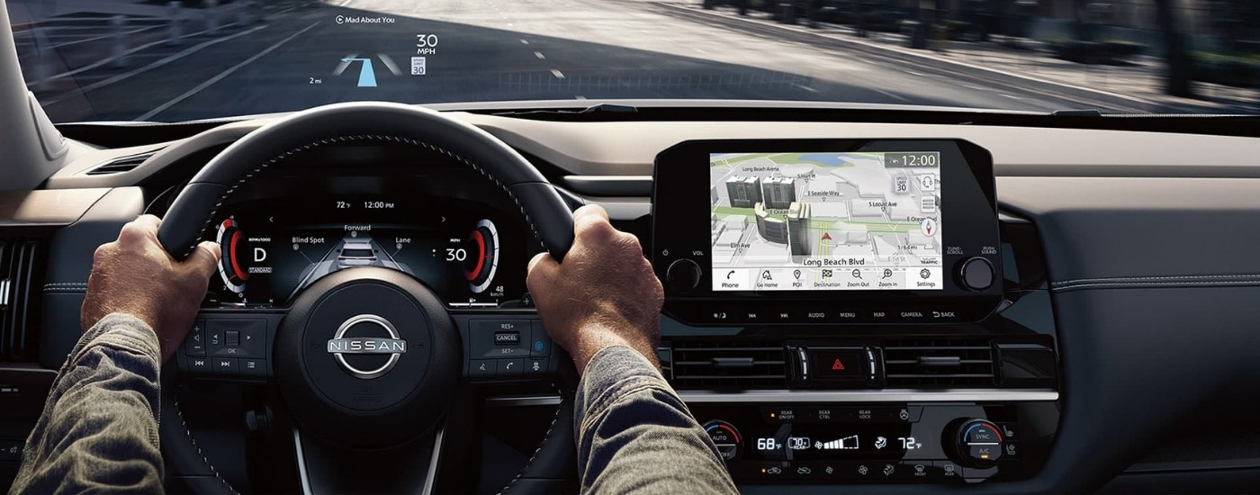 Person driving in a 2025 Nissan Pathfinder down a city street