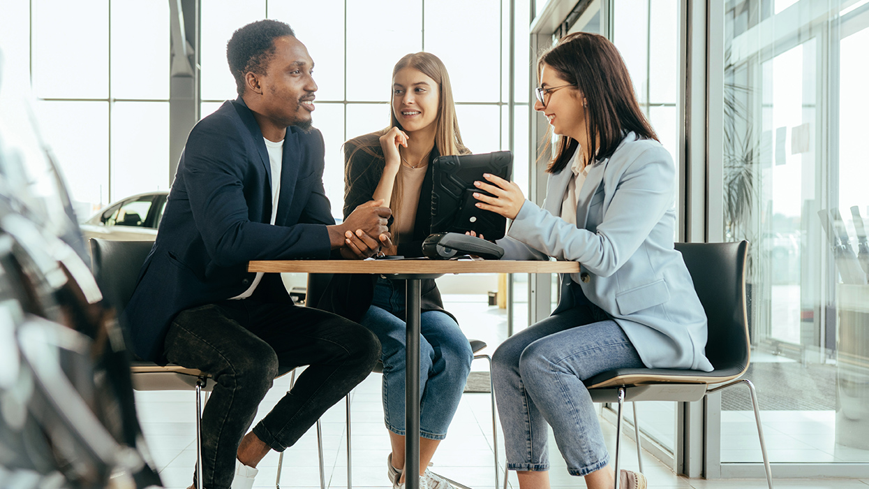 people discussing terms in car showroom