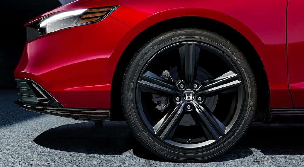 The front wheel of a red 2023 Honda Accord Sport L Hybrid.