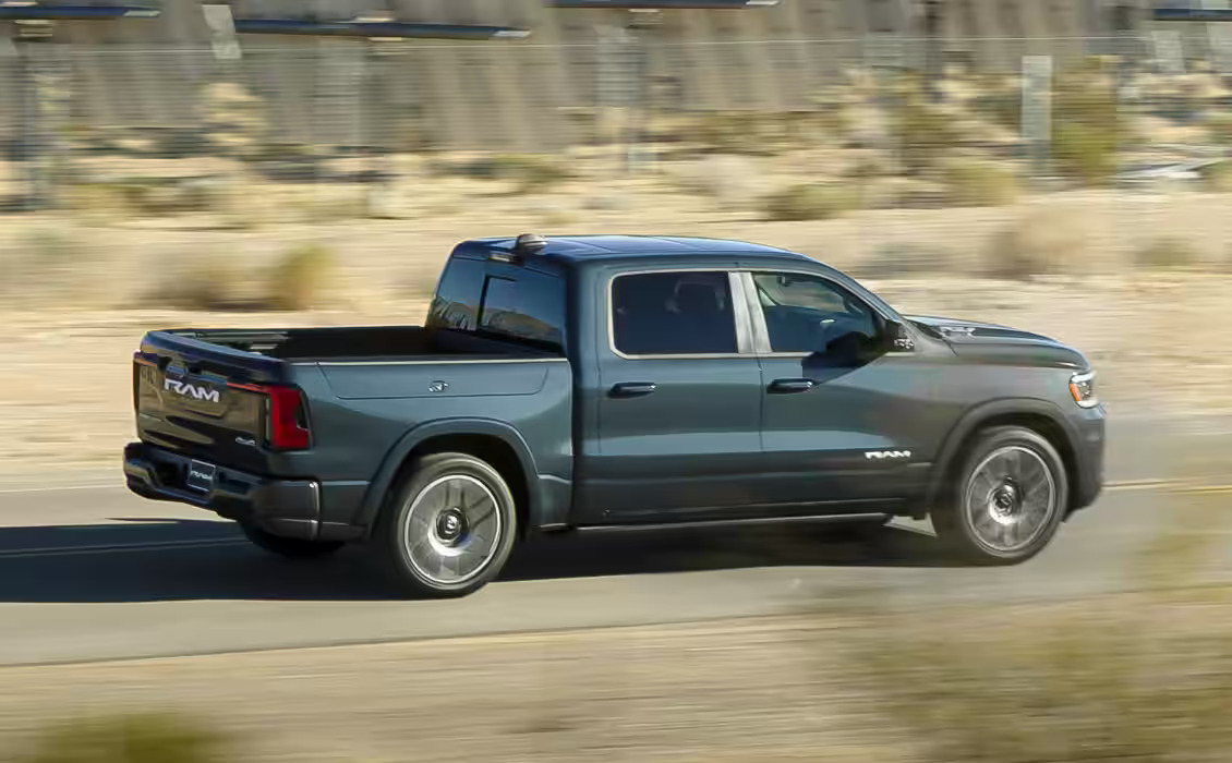 A gray truck driving on a raod.