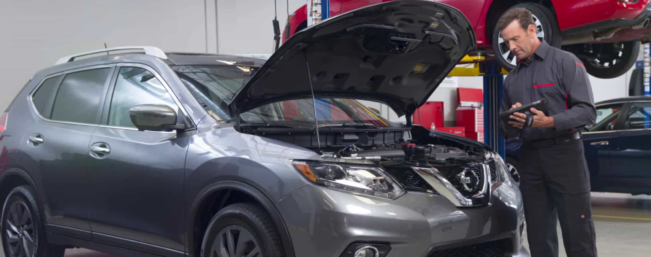 Nissan technician diagnosing a vehicle in the United Nissan service department