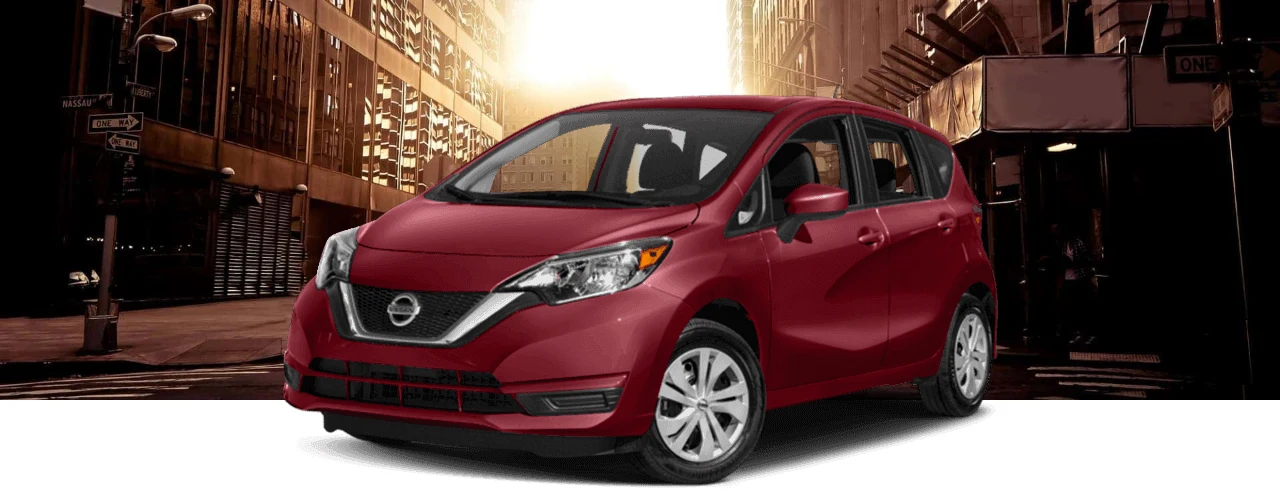 Red 2017 Nissan Versa Note hatchback on an empty city street