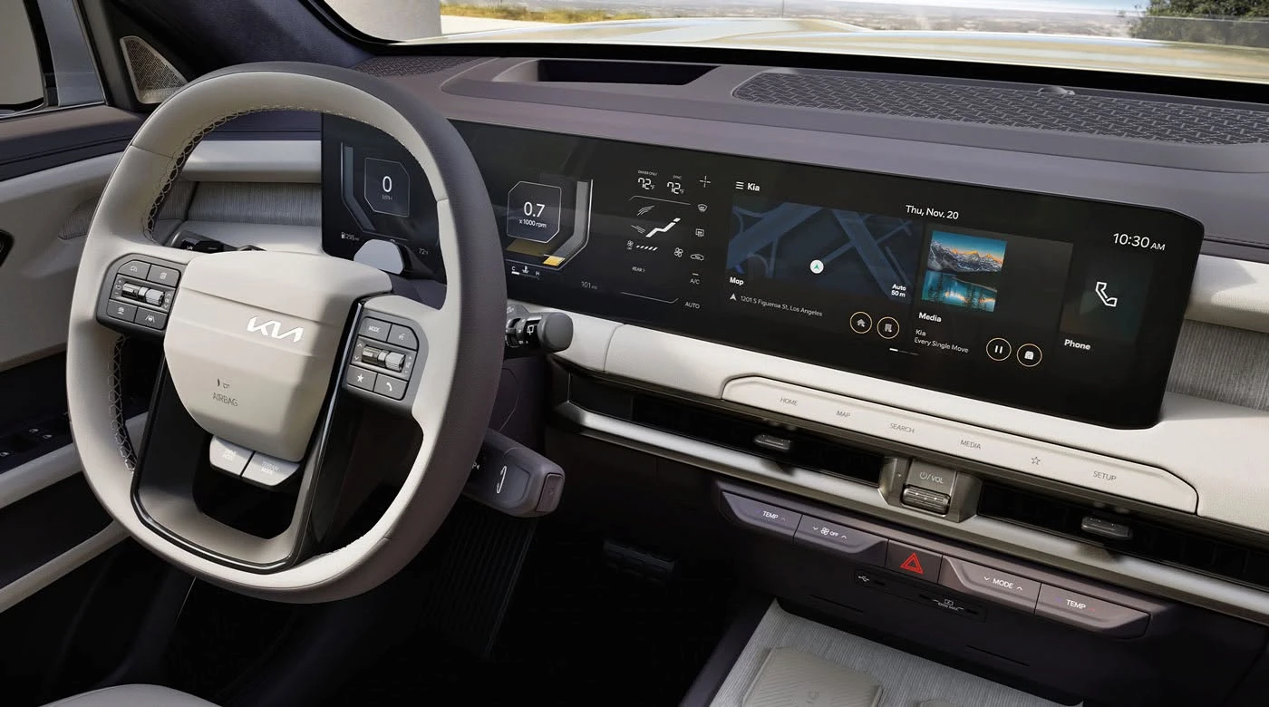 Interior of a 2027 Kia Telluride Hybrid showing the steering wheel, dual-zone climate control readout, and widescreen infotainment display with map, media, and phone widgets.