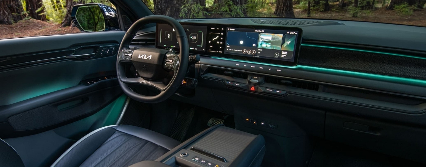 Green ambient lighting in the cabin of a 2024 Kia EV9 parked in the woods