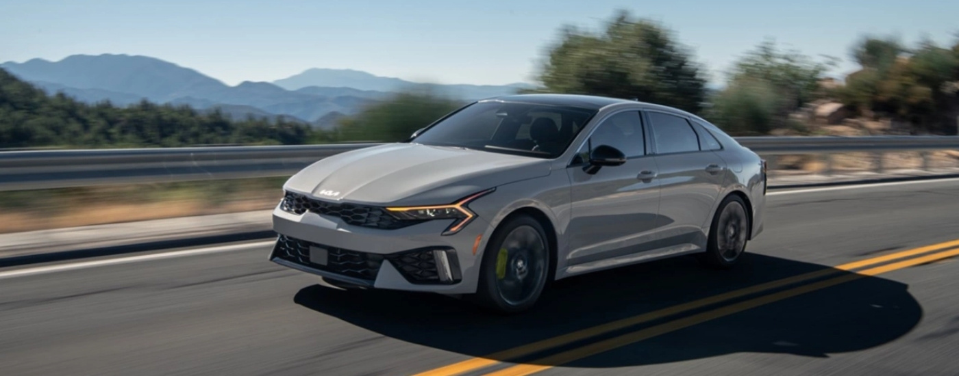  Grey 2025 Kia K5 for sale driving down a road