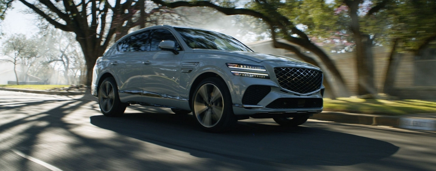 Grey 2025 Genesis GV80 Coupe driving to a Genesis dealer near Pike Road