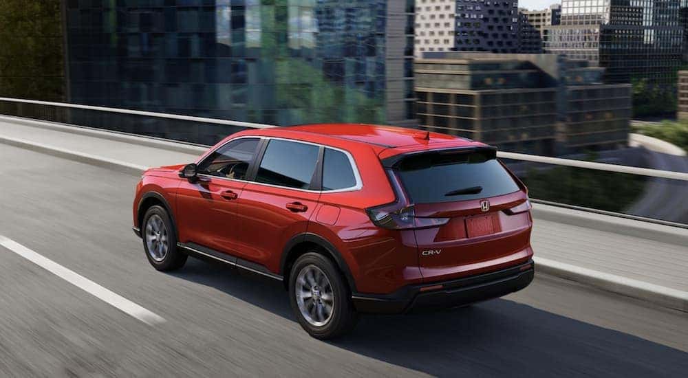 Red 2023 Honda CR-V EX for sale driving through a city