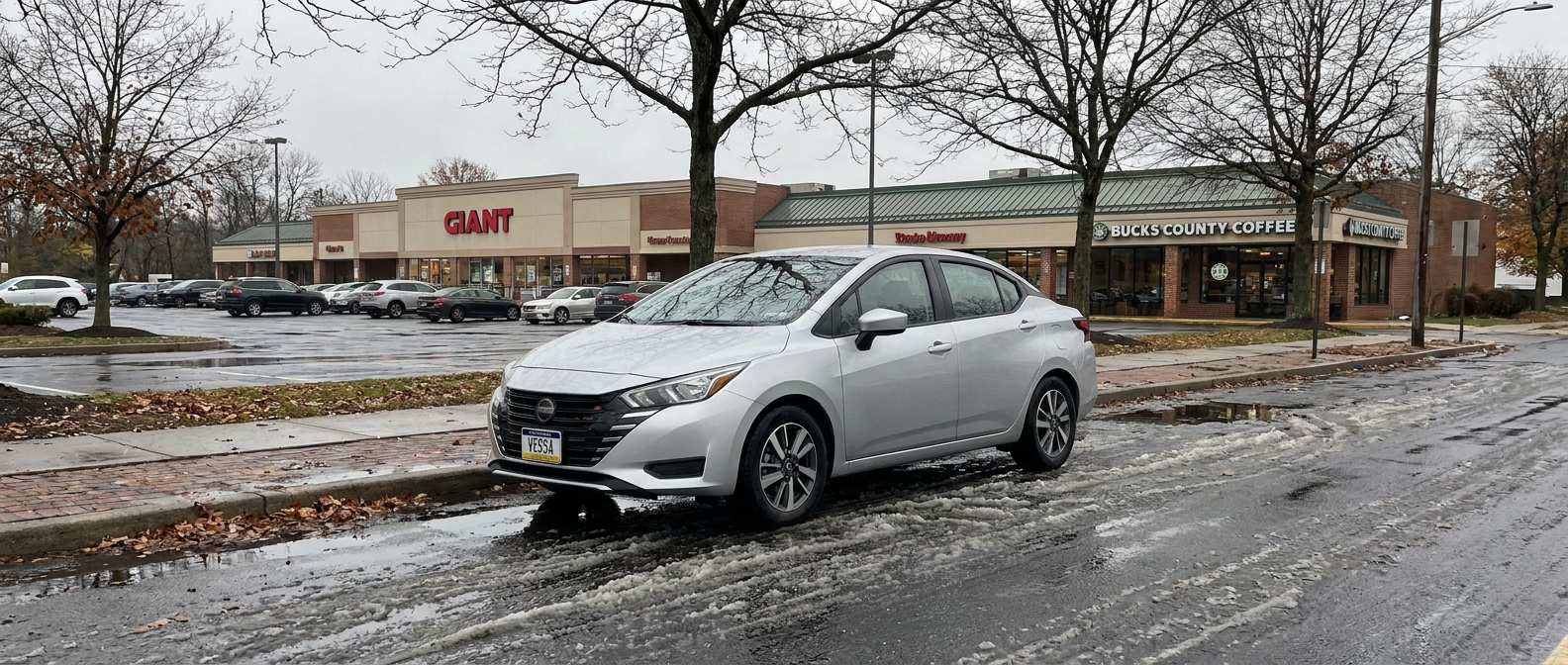 Used 2021-2025 Nissan Versa sedan on a wet suburban Bucks County street in autumn