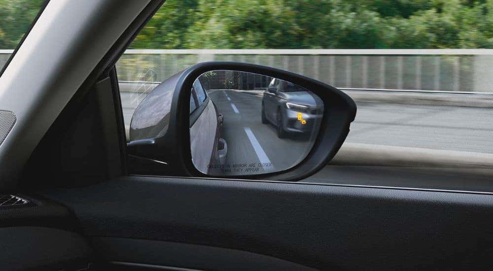 Close-up of the side mirror, with illuminated blind spot alert, on a 2025 Honda Accord Hybrid.