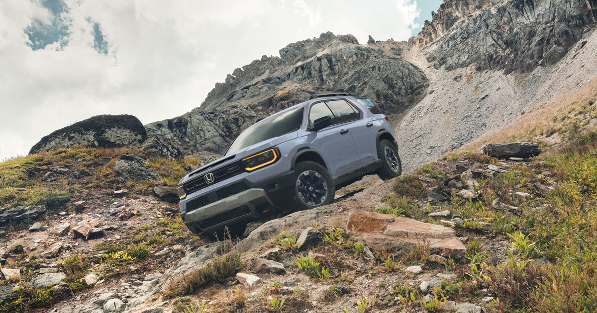 A 2026 Honda Passport driving down a rocky hill off-road.