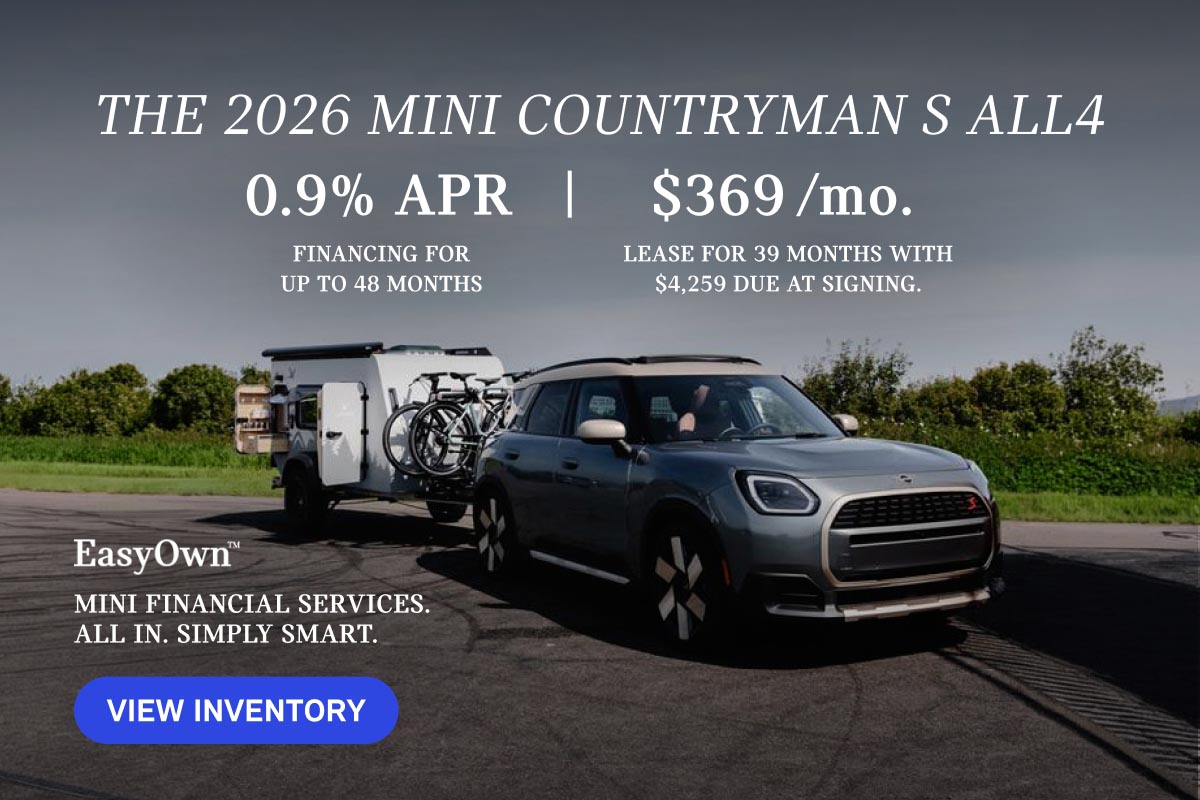 Grey MINI Countryman parked with bicycles and trailer in tow.