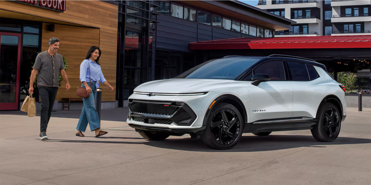 A couple walking to the chevrolet Equinox EV.