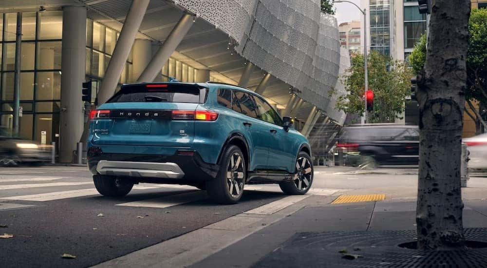 A turquoise 2024 Honda Prologue Elite is shown stopped on a city street. 