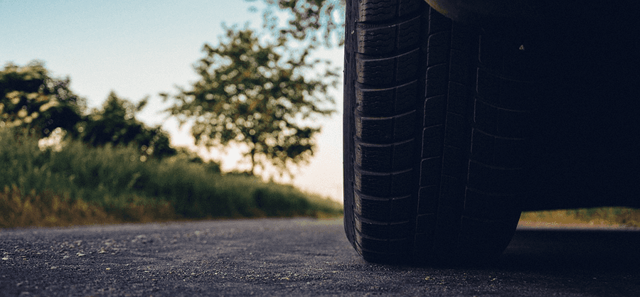 Close-up of a tire on a road at sunset