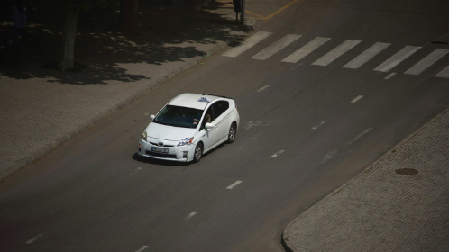 Toyota Prius in white paint driving down a Missouri road.