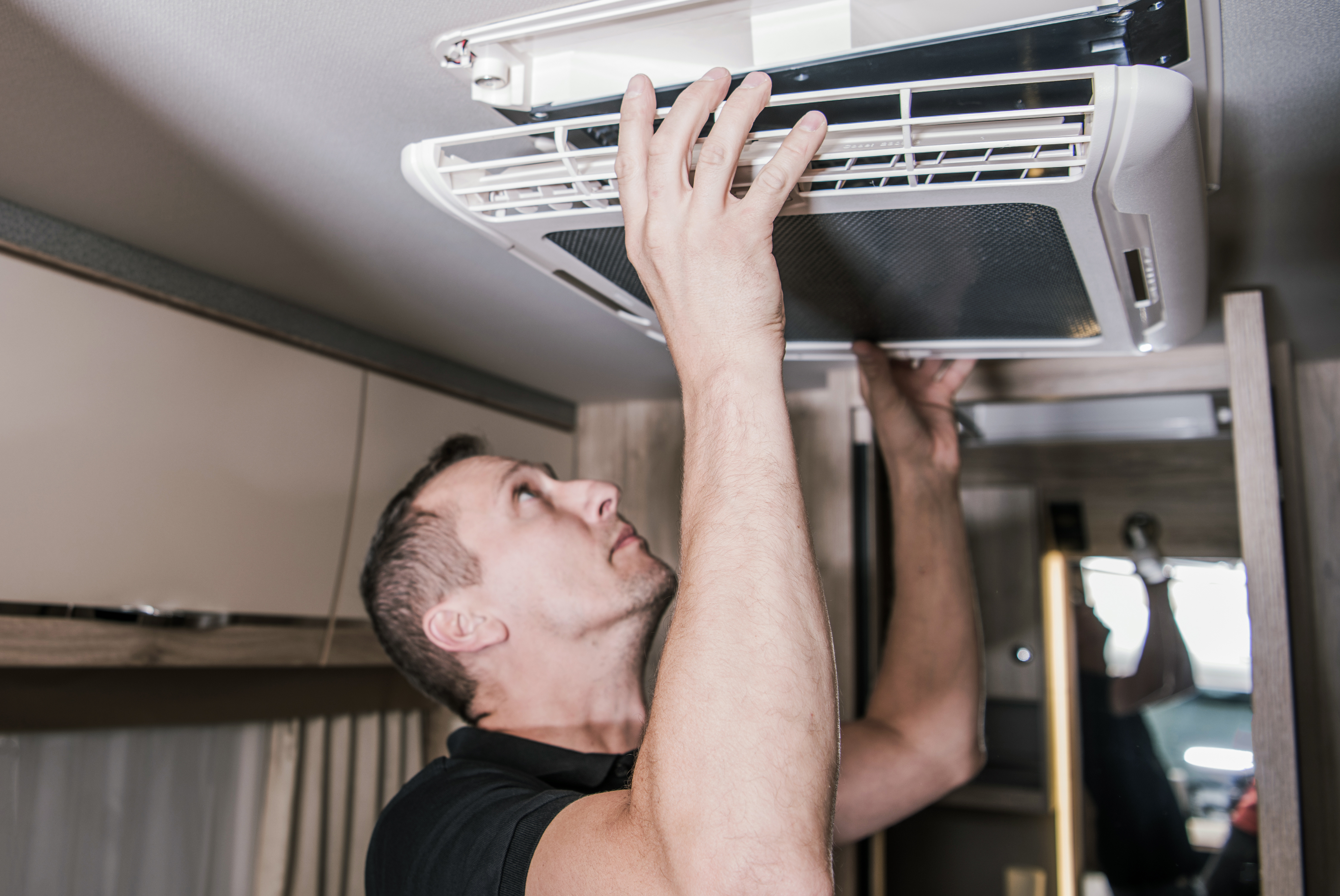 Kunes RV Technician inspects air conditioning in a RV for a seal tech test