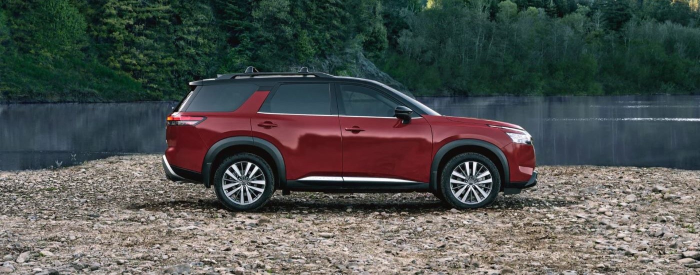 Red 2023 Nissan Pathfinder parked near a lake