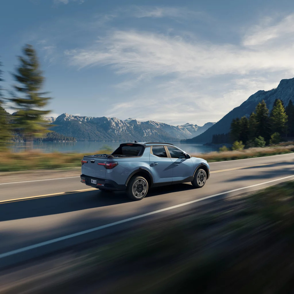 A blue car driving on a road.