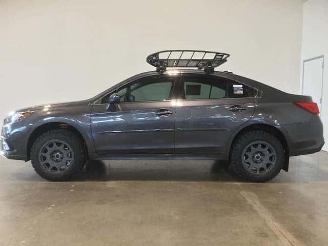 Lifted gray Subaru Legacy with off-road tires and a roof basket
