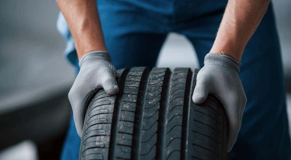 A mechanic is shown handling a tire at a tire shop.