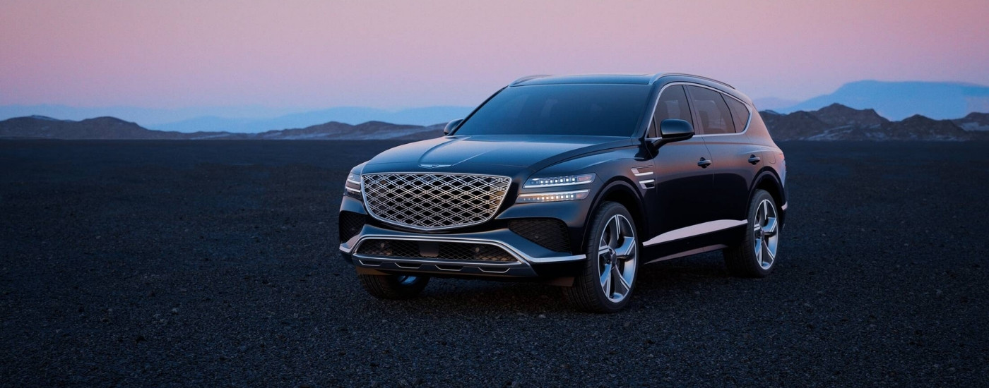 A black 2025 Genesis GV80 parked off-road.