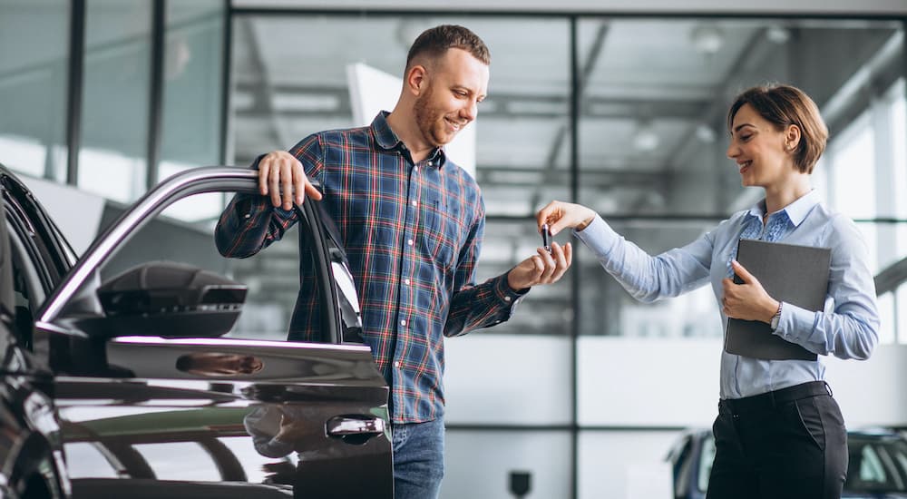 Salesperson handing customer a set of car key