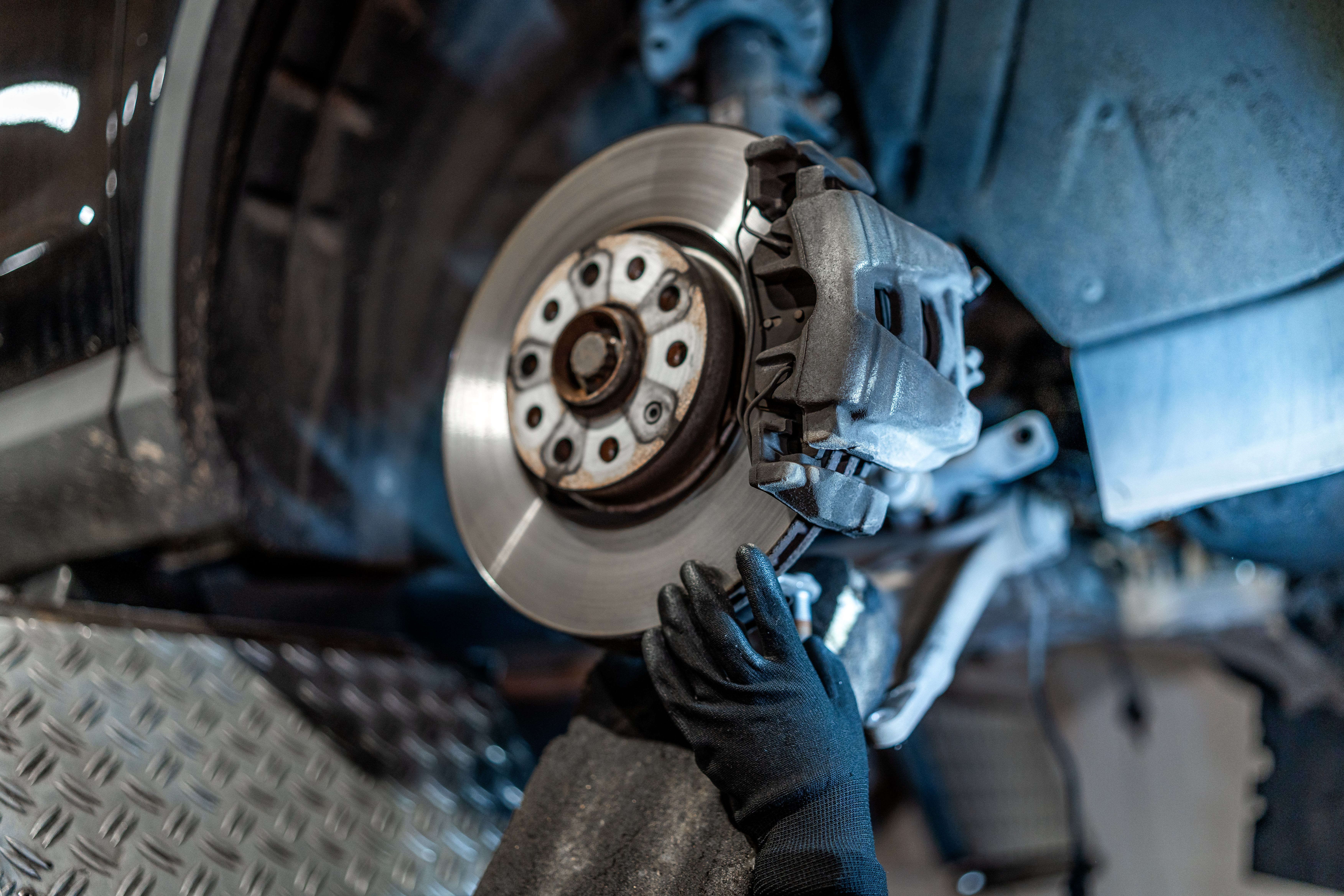 Certified auto technician inspecting brake rotors and pads for a vehicle in Wichita, KS