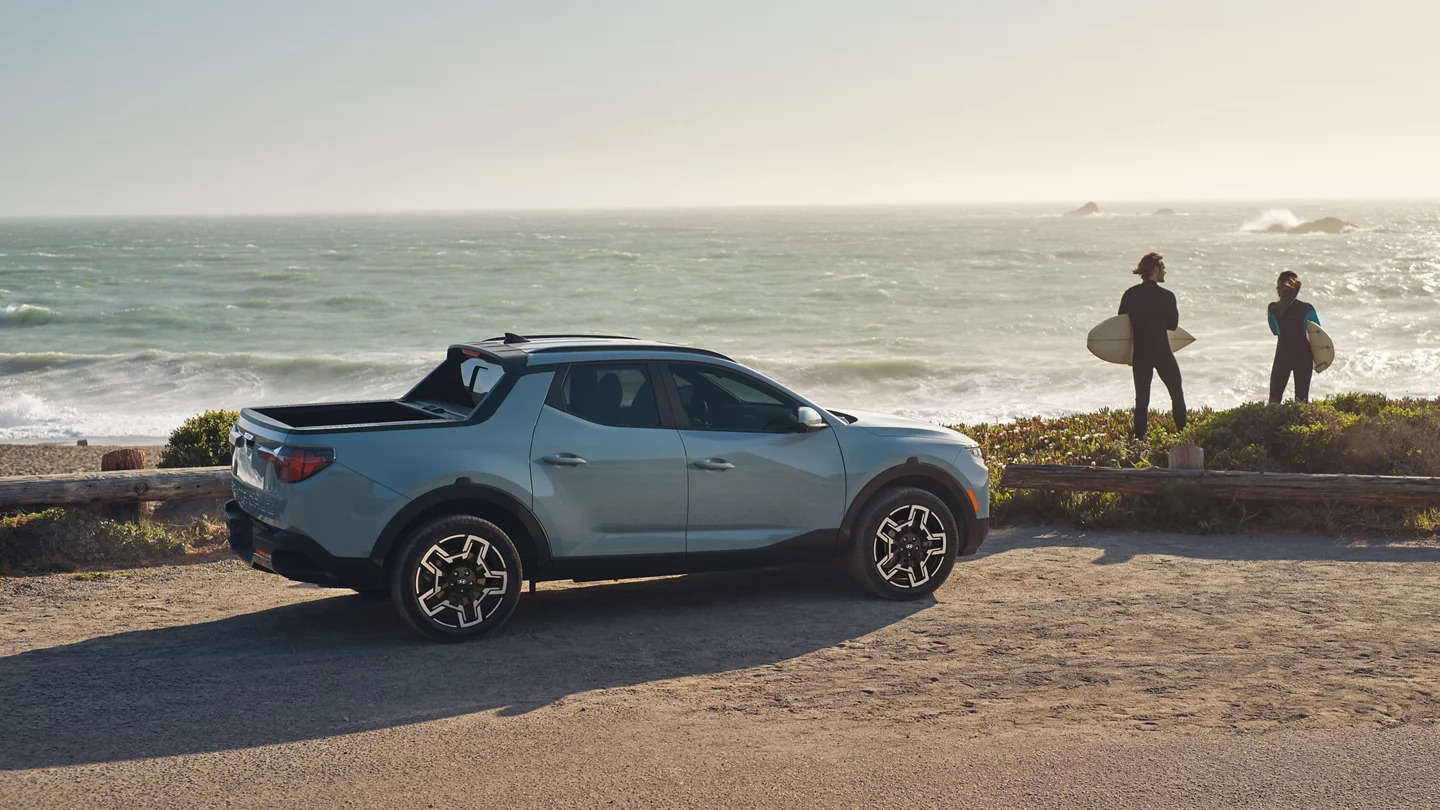 a blue car parked by the beach.