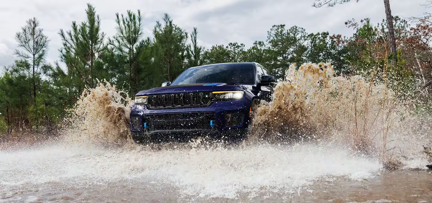 a blue car driving through some water.