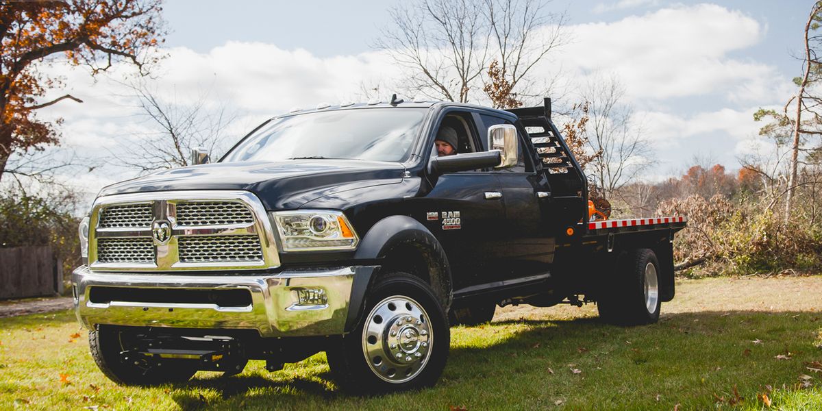 a black RAM 4500 HD with a black flat bed in a residential backyard.