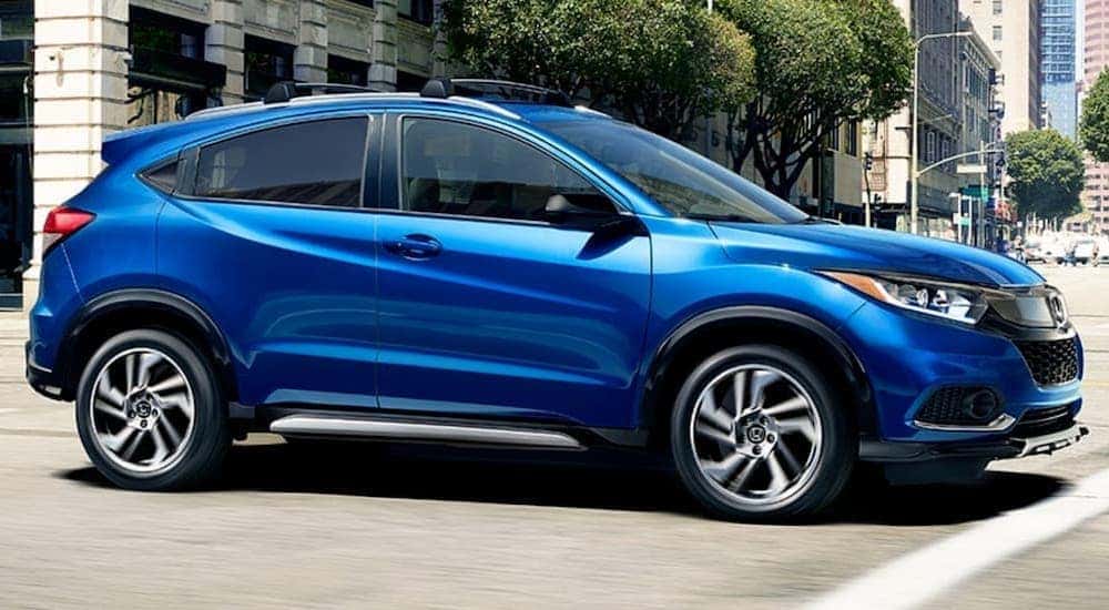 A blue 2020 Honda HR-V Sport is shown driving to a used Honda dealership near Greece.