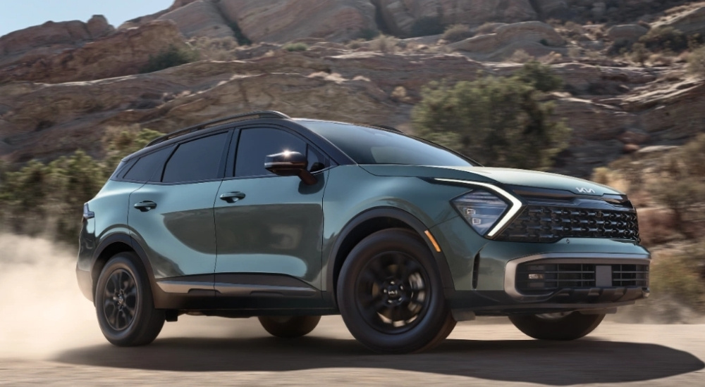 Green 2025 Kia Sportage X-Pro Prestige driving on a dusty trail
