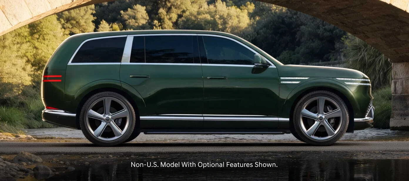 Green Genesis GV90 shown in side profile beneath a stone bridge.