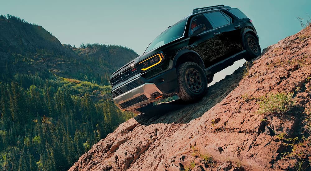 Black 2026 Honda Passport driving off-road down a hill.