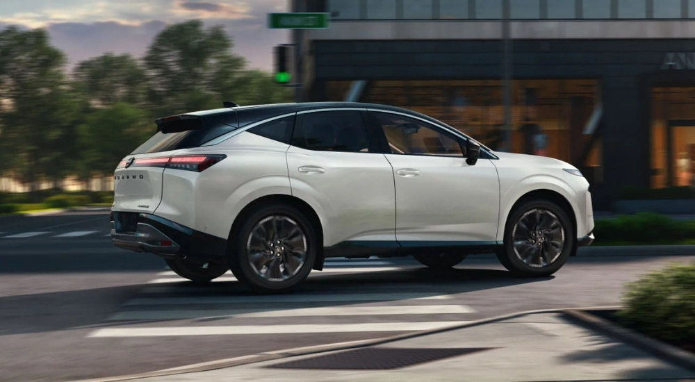 Side of a white 2025 Nissan Murano driving in a city