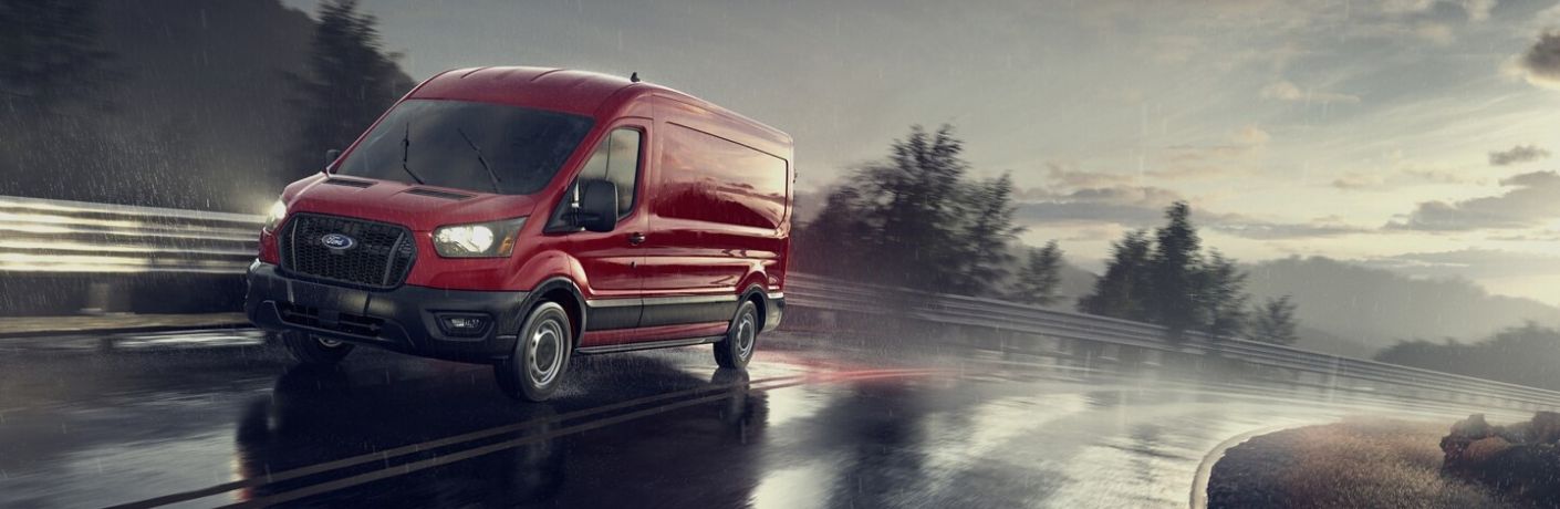 Red 2024 Ford Transit Driving on a Wet Highway