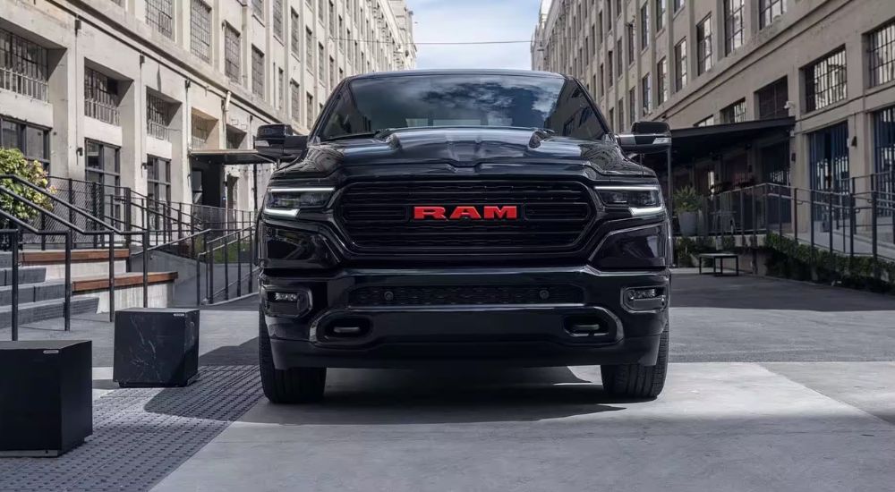 A black 2023 Ram 1500 Limited parked in a city.