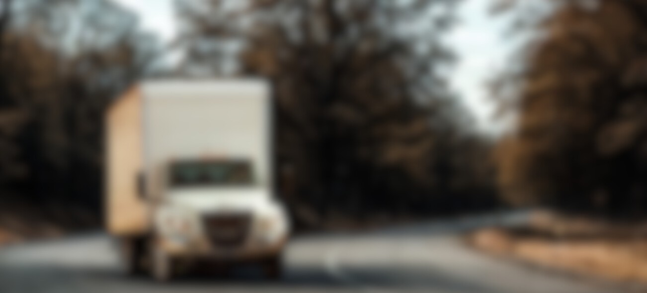 International MV Box truck on highway with trees in the background