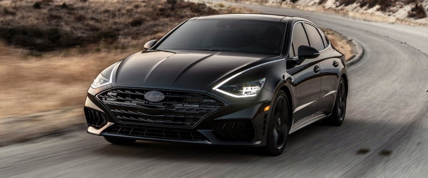 A black 2022 Hyundai Sonata driving on the road.