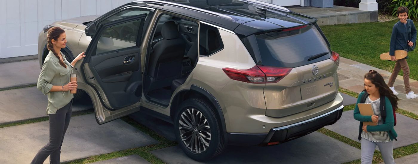 A family getting into their tan 2026.5 Nissan Rogue Platinum.