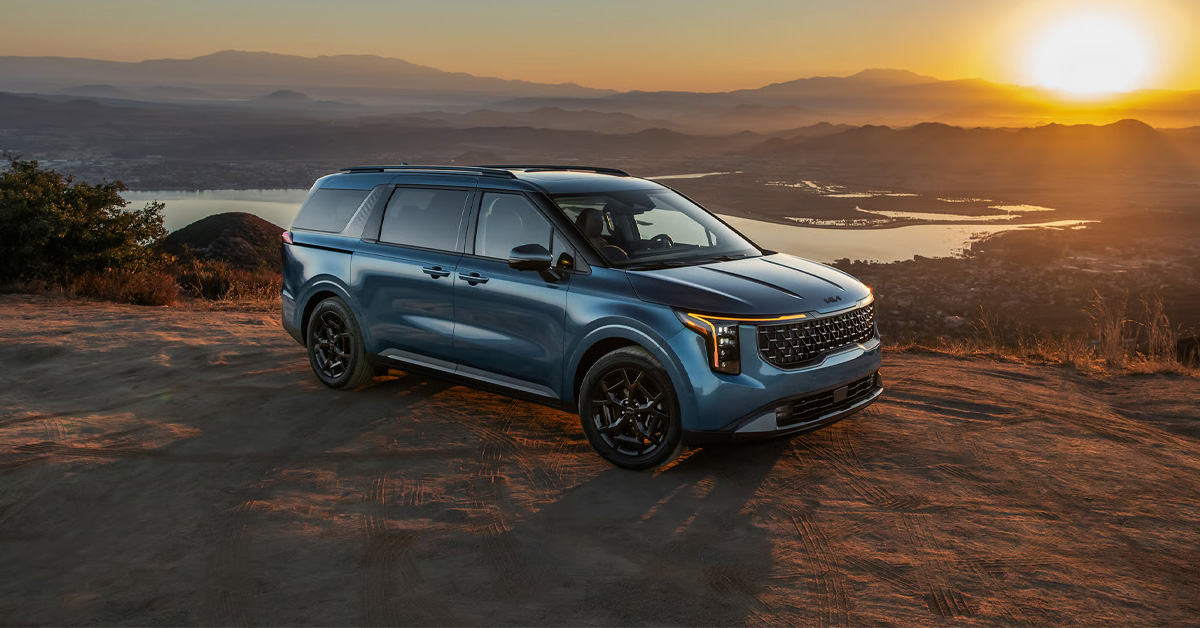 2026 Kia Carnival parked on a rugged sun-drenched dirt overlook at sunrise