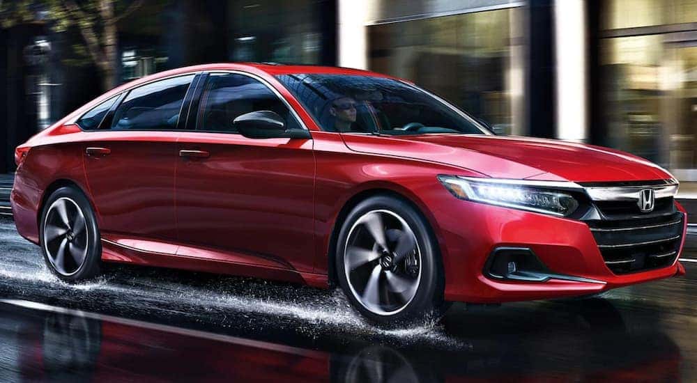 A red 2021 Honda Accord is driving down a wet road.