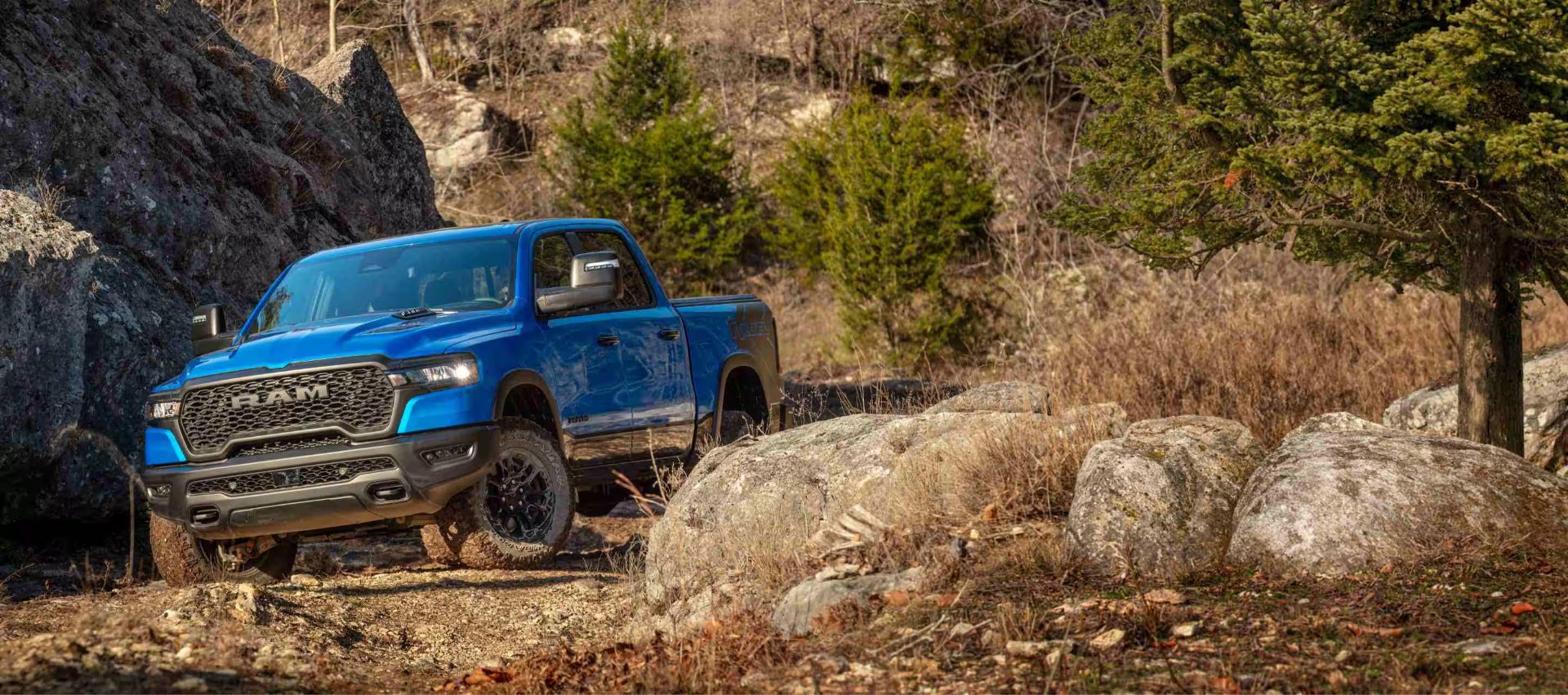 a blue ram 1500 driving in the woods
