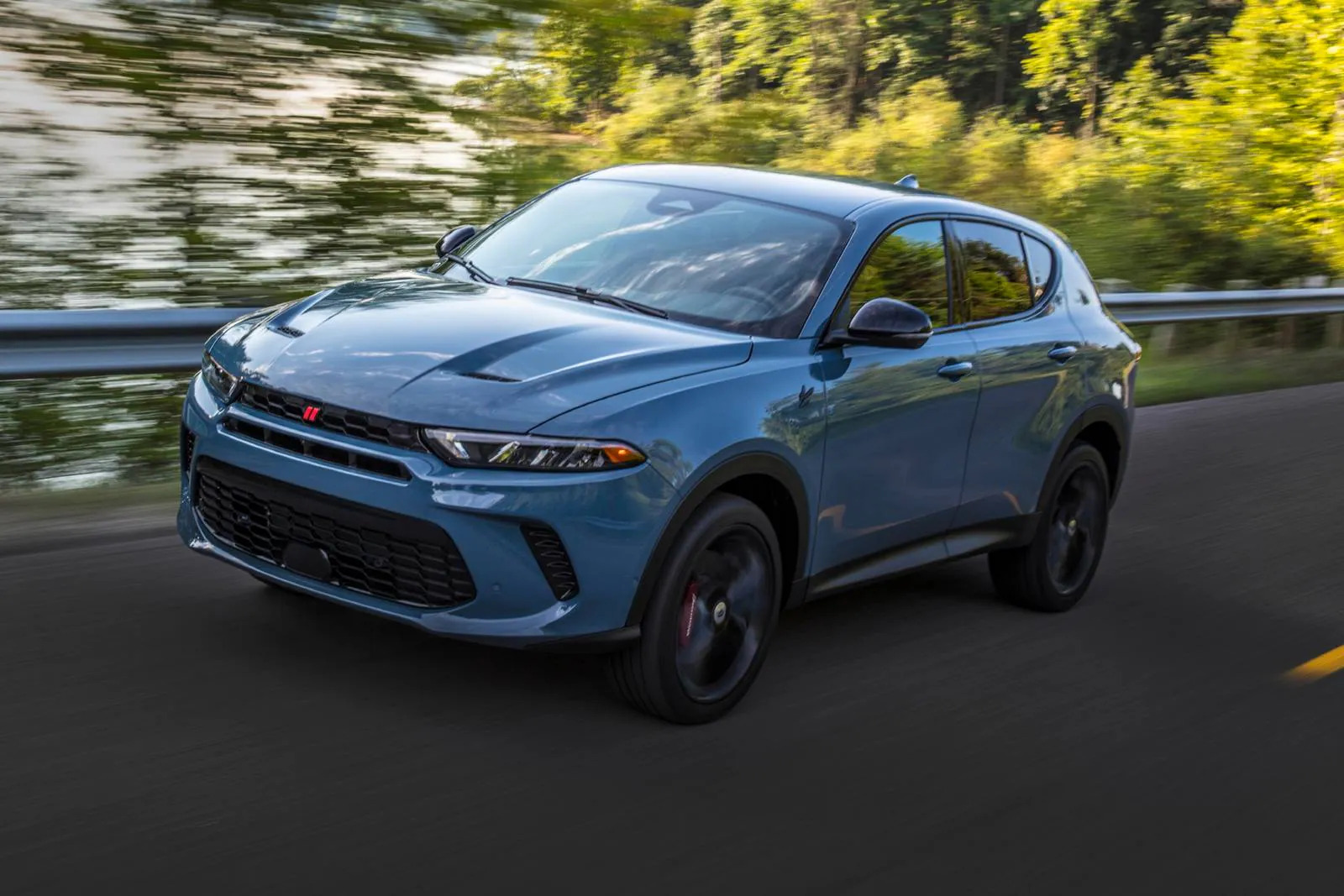 A blue car driving on the road.