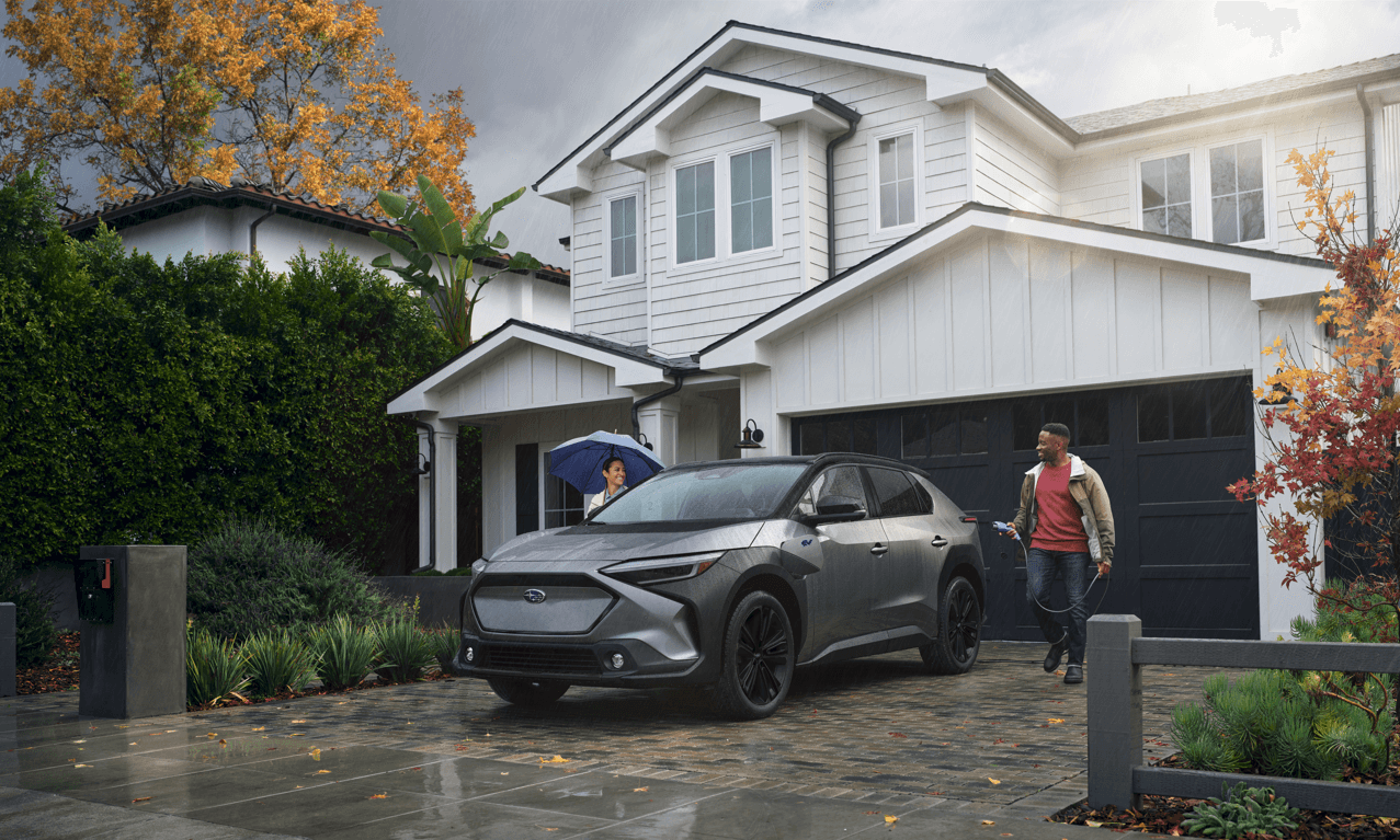 Gray Subaru Solterra parked outside a modern home