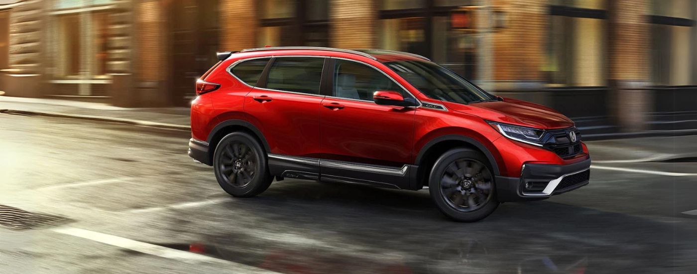 Red 2021 Honda CR-V Touring driving on a city street
