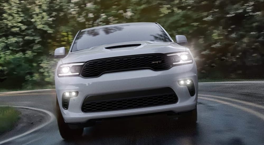The front of a white 2022 Dodge Durango SRT driving on a winding road.