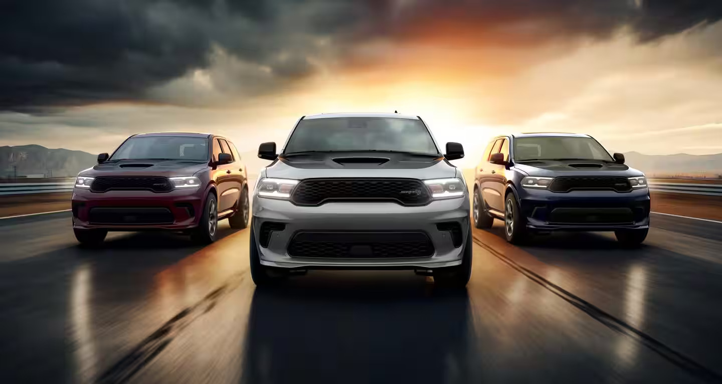 Three dodge durangos driving on the road.