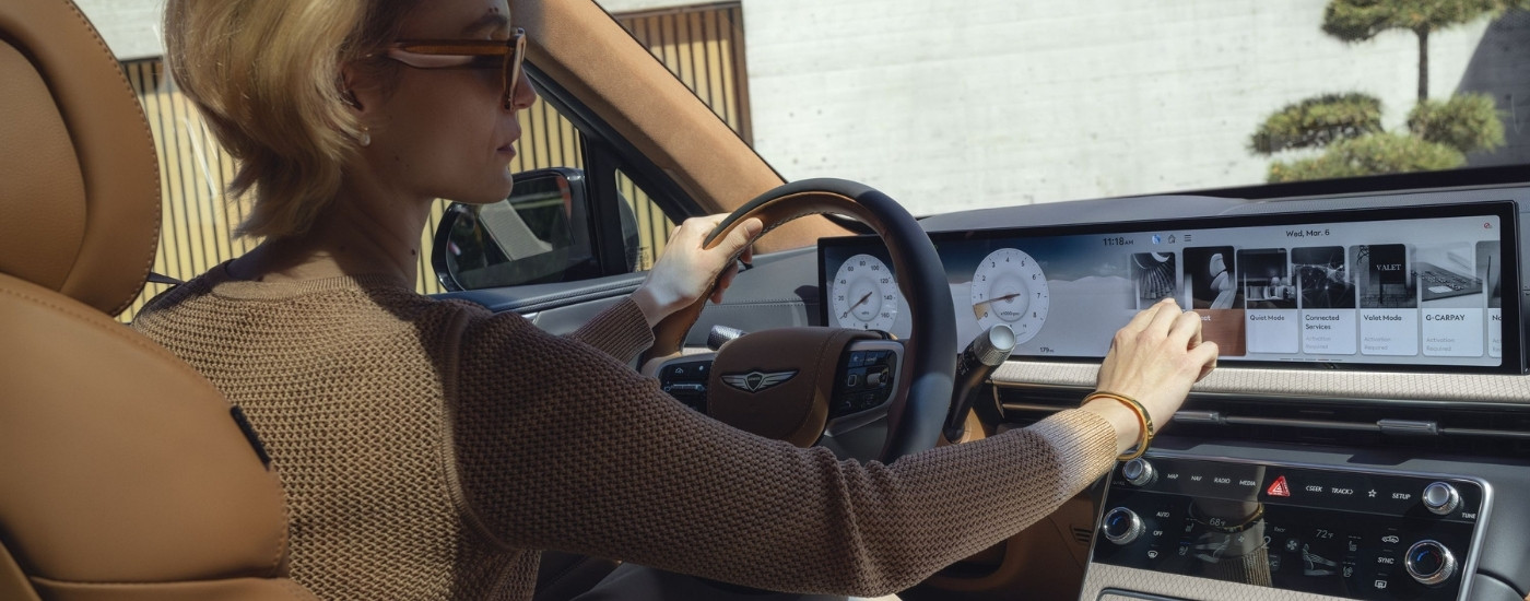 Person driving in a 2025 Genesis GV80 for sale near Auburn