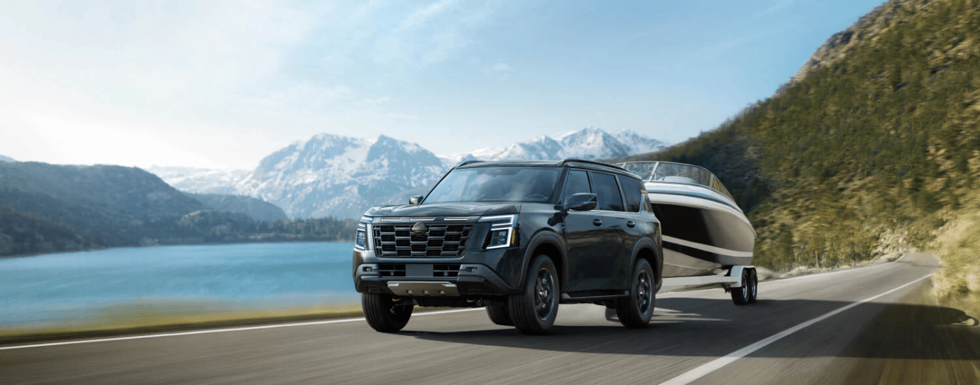 Black 2026 Nissan Armada towing a boat around a lake
